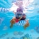 A girl making finger hearts while snorkeling with fish in Cozumel, Mexico